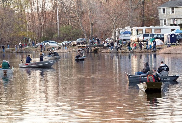 Boats jockey for position as the shore is lined with anglers, trucks, tents and RVs