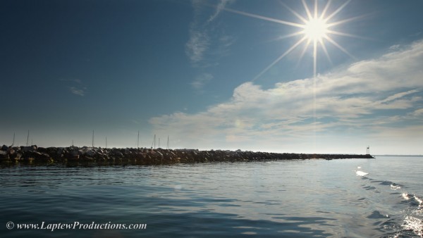 sun shines down on breakwater in Little Narragansett Bay